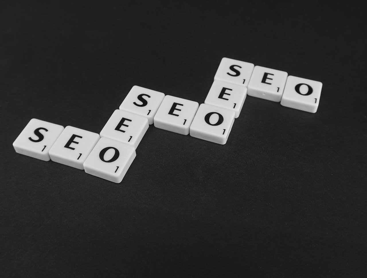 why-choose-us SEO spelled with Scrabble tiles on a black surface, representing search engine optimization concepts.